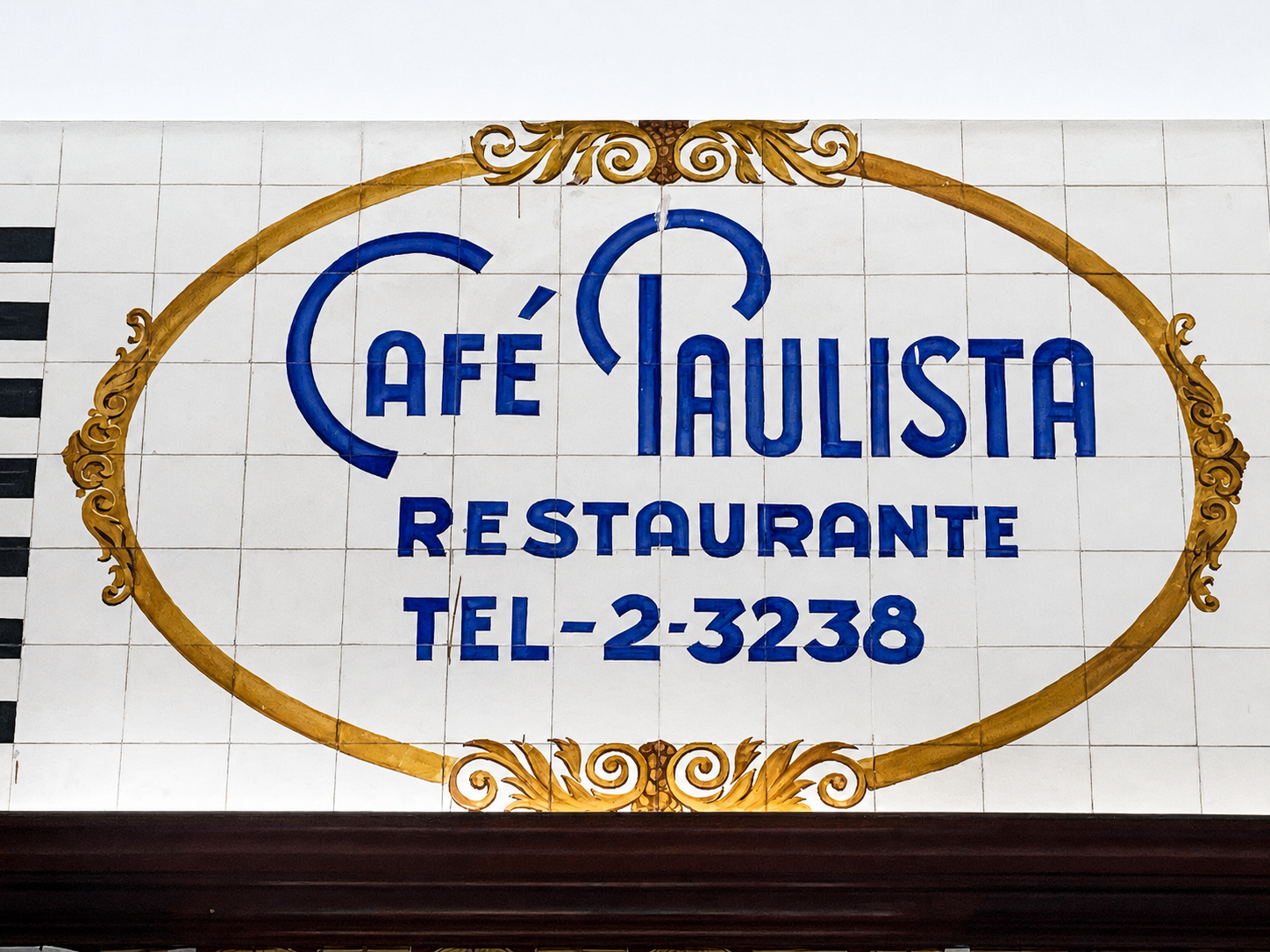 Painel histórico em azulejos com o nome Café Paulista Restaurante em letras azuis